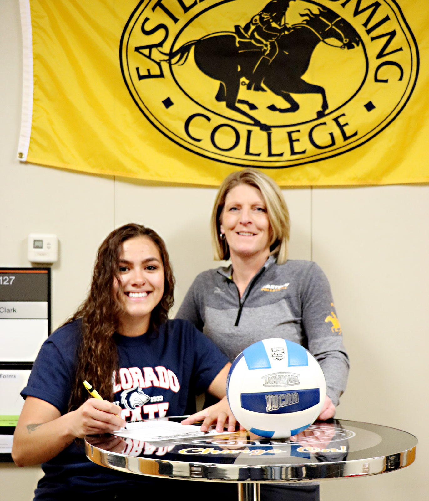 Lissette Lefforge with former EWC Volleyball Coach Julie Sherbeyn as she signs her commitment to Colorado State University-Pueblo.