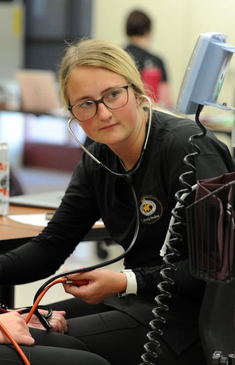 Female Eastern Wyoming Nursing Student using stethoscope in class